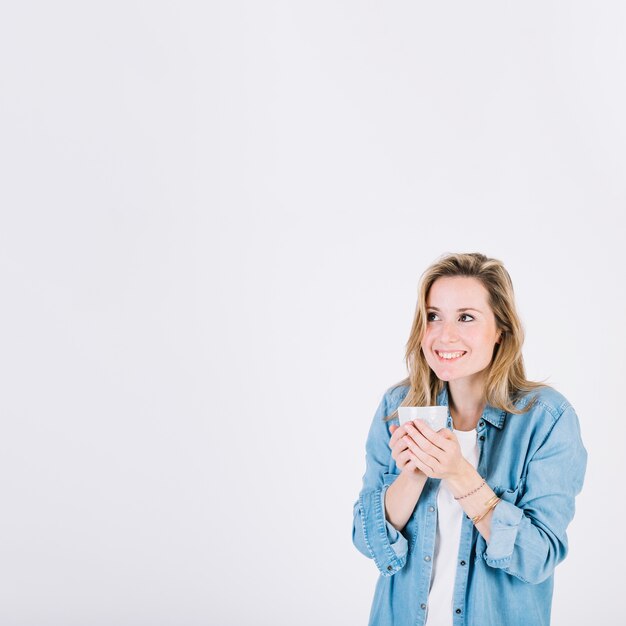 Dreaming woman with mug of hot drink