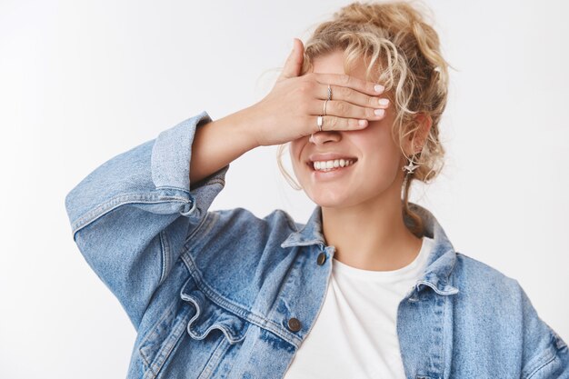 Dreamy creative charming cute girlfriend blond curly hairstyle stylish accessorize denim jacket close eyes palm smiling broadly anticipating surprise waiting birthday gift, playing hide and seek