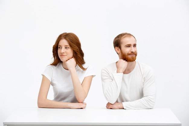 Dreamy cute redhead man and woman look away