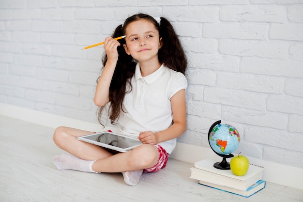 Dreamy girl sitting with tablet