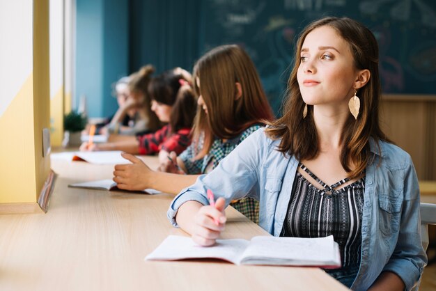 デスクで夢のような女の子の学生