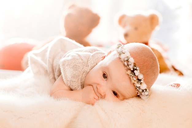 Dreamy little girl lies on fluffy blanket in a bed 