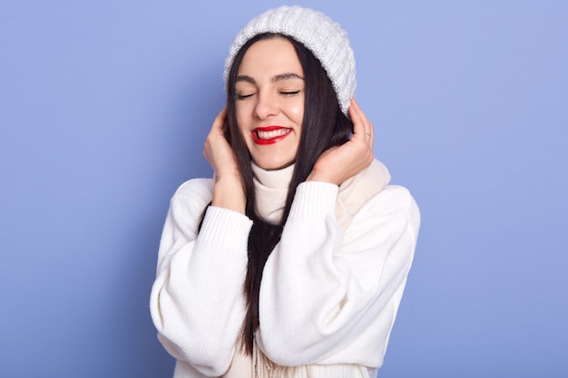 Dreamy pretty caucasian brunette young female wearing white warm sweater