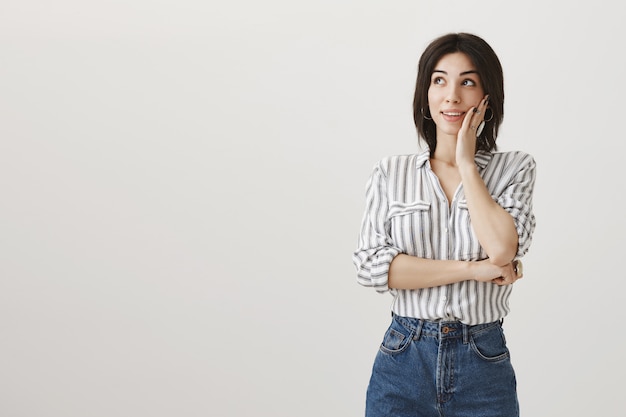 Femmina sciocca vaga del brunette che osserva nell'angolo superiore sinistro soddisfatto