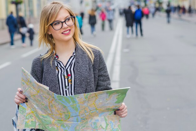 Dreamy smiling woman with map