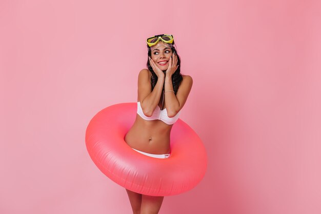 Dreamy tanned woman posing with swimming circle