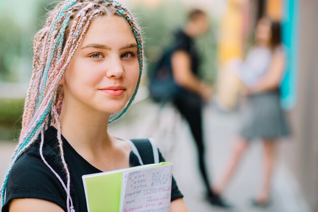 Foto gratuita scolara teenager sognante con il libro di testo