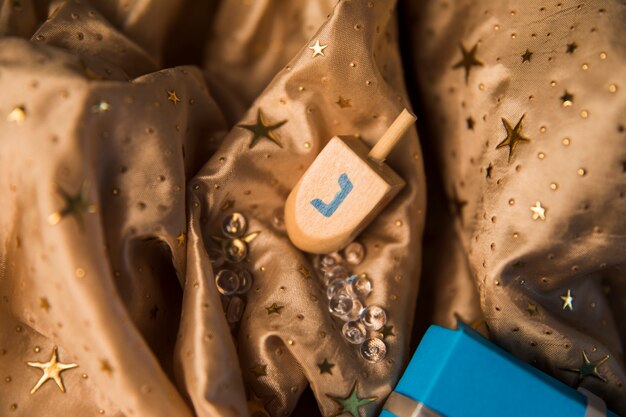 Dreidel and beads lying near gift