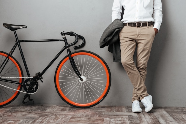 Free photo dressed half mens body standing near a bicycle