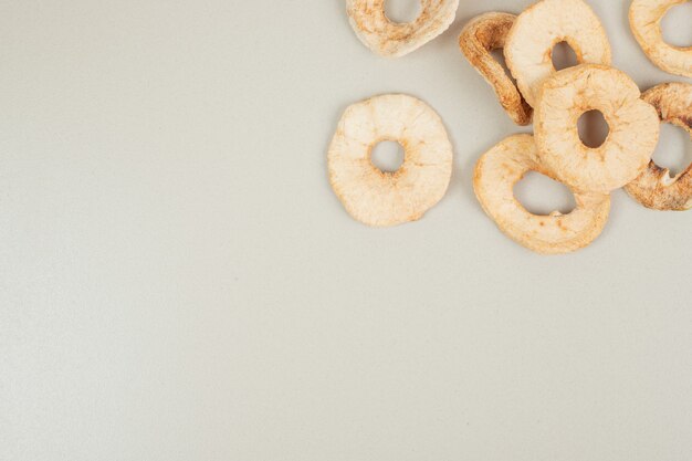Dried apple chips on gray surface