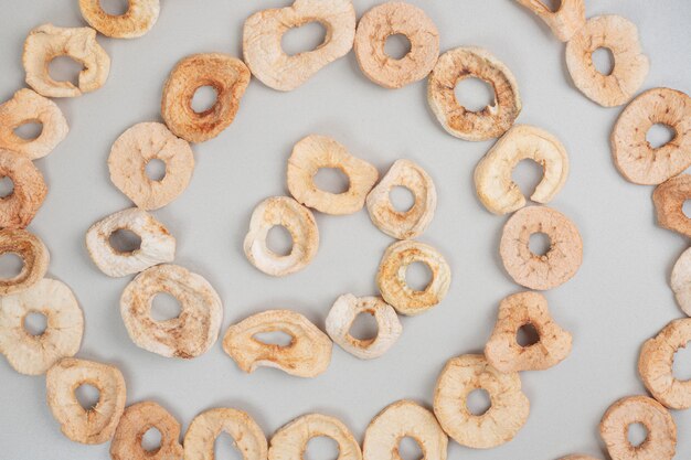 Dried apple chips on gray surface