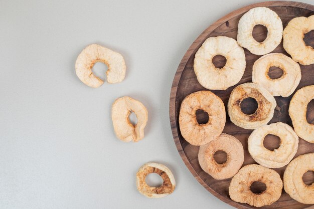 Dried apple chips on wooden plate