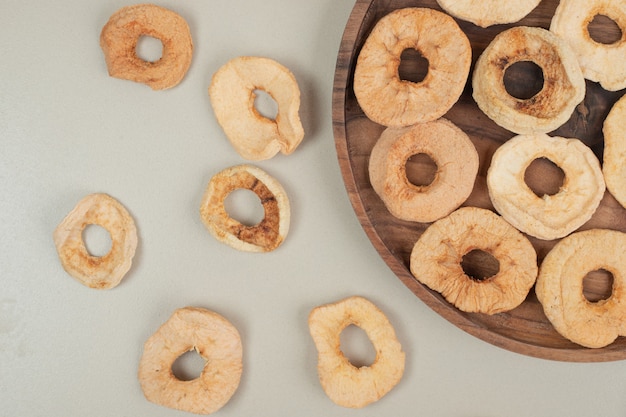 Dried apple slices on wooden plate