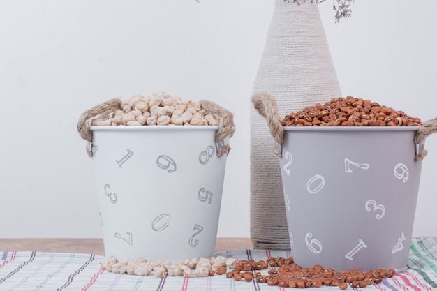 Dried beans and peas in buckets with flowers.