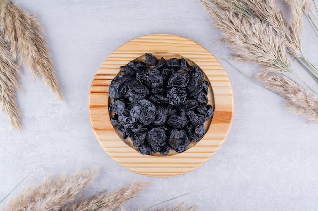 dried black sultanas in a plate on concrete background. high quality photo