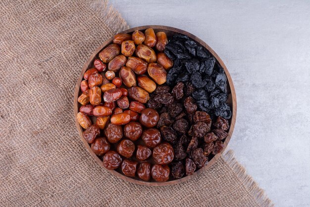 Dried cherries, berries and dates on a wooden platter. High quality photo