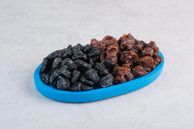 Dried cherry and plums in a blue platter.