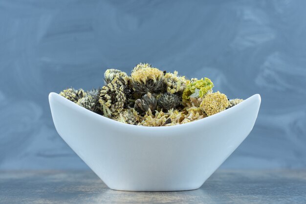 Dried chrysanthemum petals on white plate.