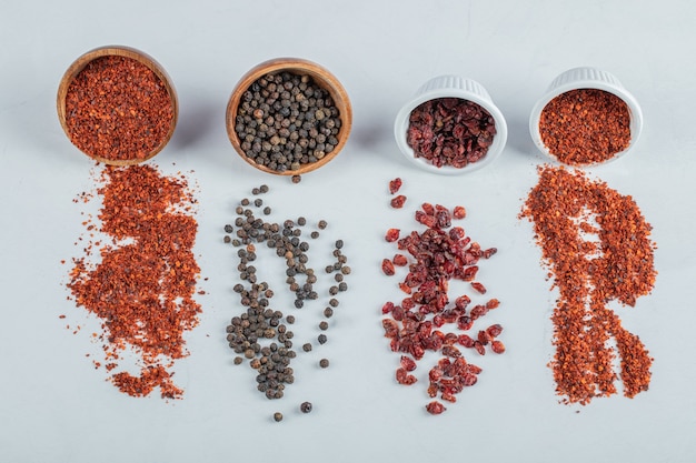 Dried cranberries and various spices on a white surface.