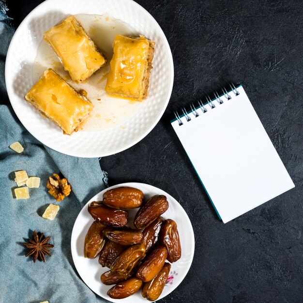 Dried dates fruit with eastern sweets and notepad