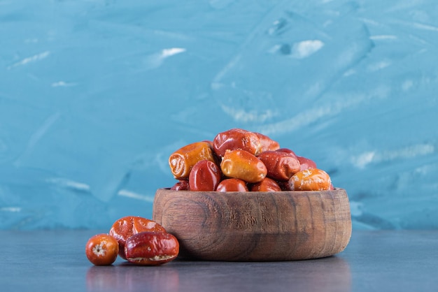 Dried elaeagnus in a wooden bowl, on the marble surface