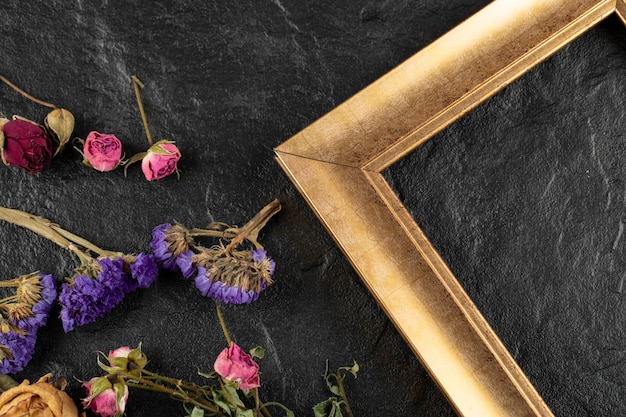 Бесплатное фото Сухие цветы с рамкой на черном столе.
