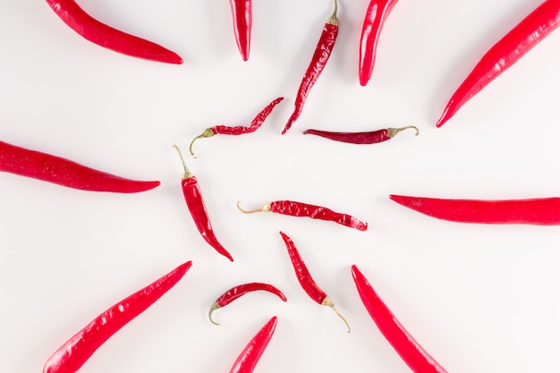 dried and fresh red chili peppers top view on white surface