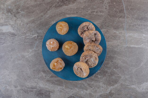 Dried fruit on the blue tray on the marble surface