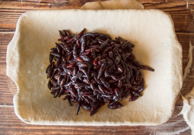 Free photo dried fruit in dough on wooden table