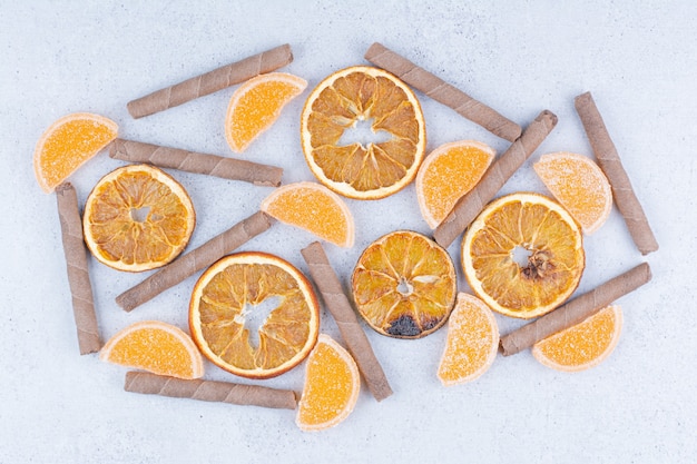 Dried fruit slices, marmalades and sticks on marble surface. 