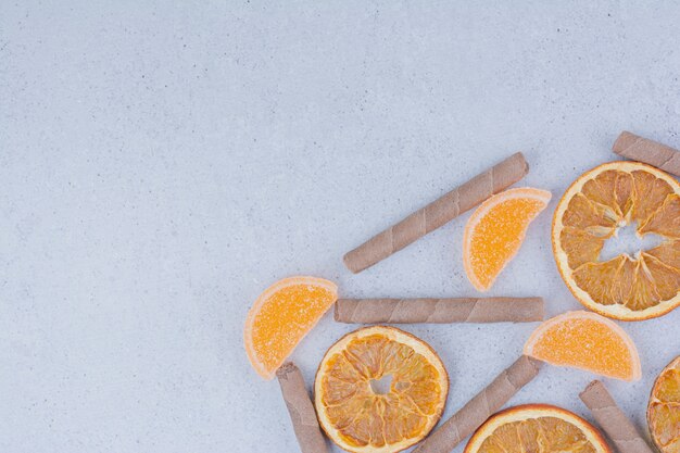 Dried fruit slices, marmalades and sticks on marble surface. 