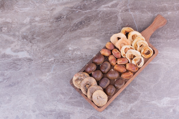 Dried fruits and berries on wooden platter.