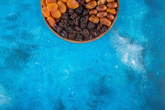 Dried fruits on a board , on the blue table. 