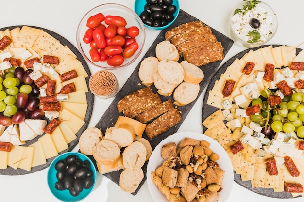 Бесплатное фото Сухофрукты, оливки, помидоры и сырное ассорти с виноградом и копчеными колбасками
