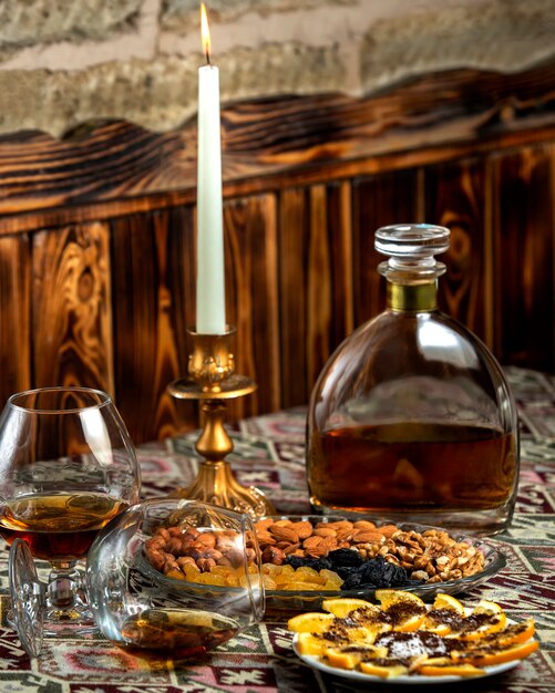 Dried fruits plate with almond, raisins, walnut served with liquor