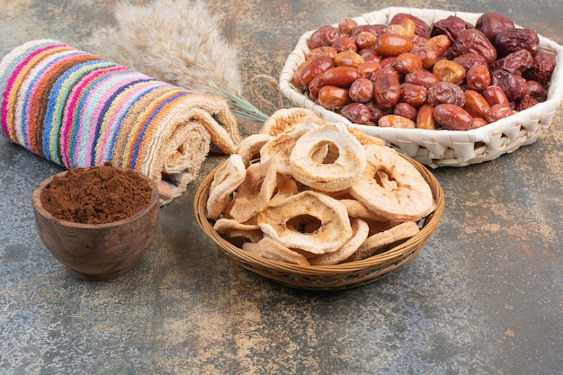 Сухофрукты с какао-порошком в деревянной миске на мраморном фоне. Фото высокого качества