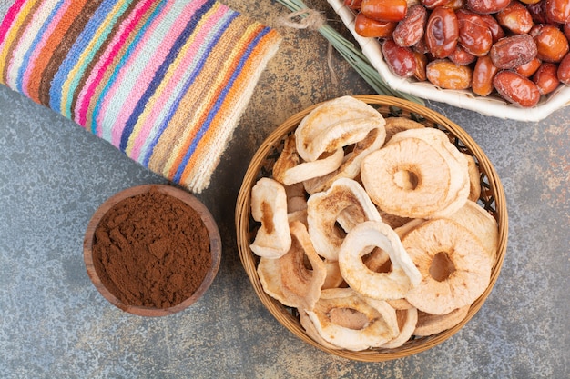 Free photo dried fruits with cocoa powder in wooden bowl on marble background.high quality photo