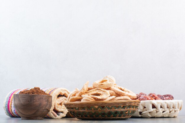 Dried fruits with cocoa powder in wooden bowl on marble background.High quality photo