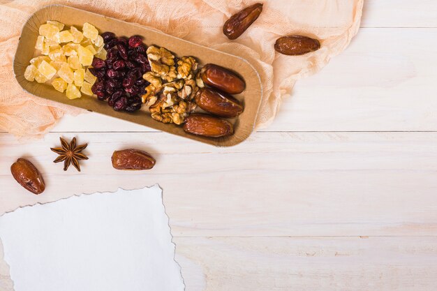 Dried fruits with walnuts and blank paper