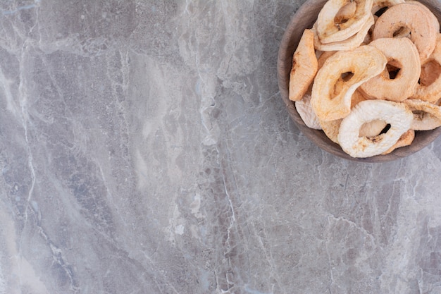 Free photo dried healthy apples on wooden plate.