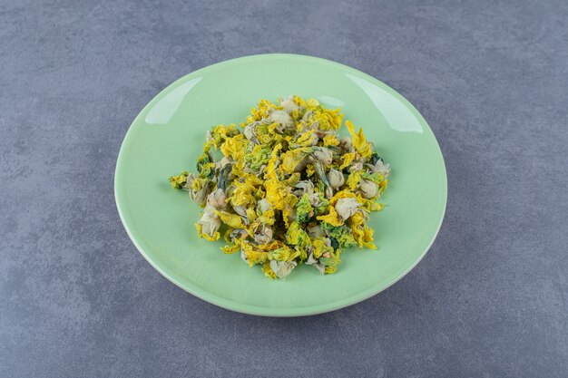 Dried healthy flowers on green plate