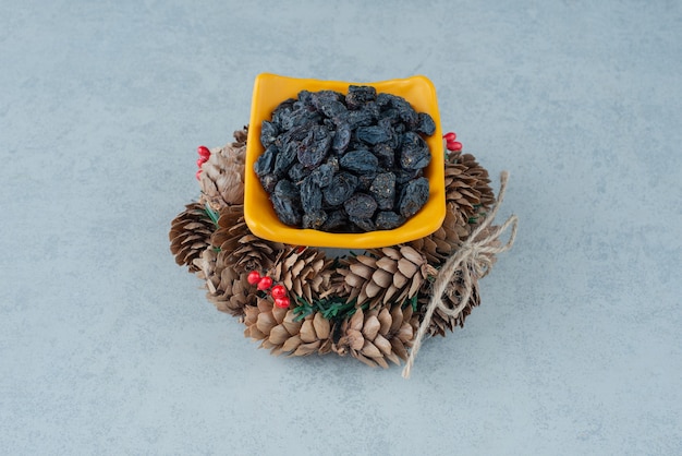 Free photo dried healthy raisin with christmas wreath from pinecones. high quality photo