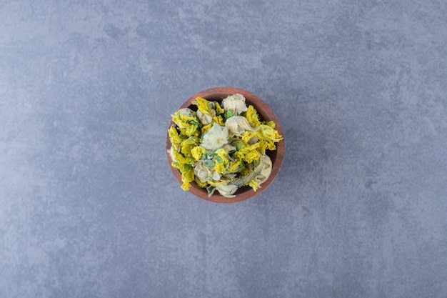 Free photo dried heathy herbs in wooden bowl . top view.