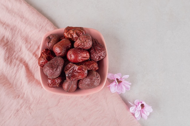 Dried indian jujube berries in a ceramic cup.