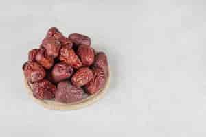 Free photo dried indian jujube berries on a wooden platter.