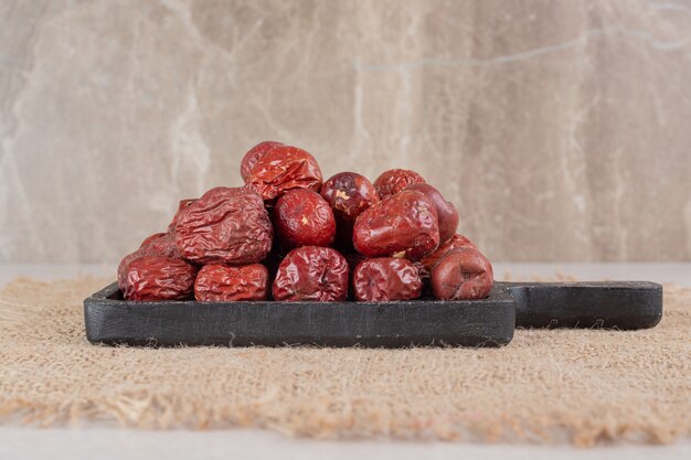 dried indian jujube berries on a wooden platter.