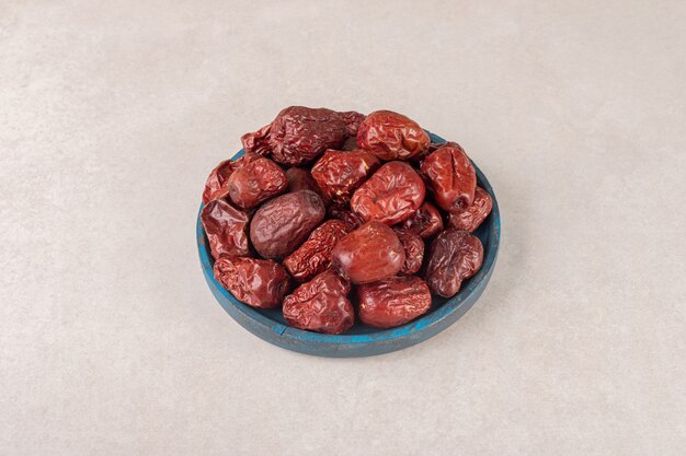 Dried jujube berries on a rustic wooden platter.