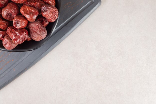 Dried jujube berries on a rustic wooden platter.