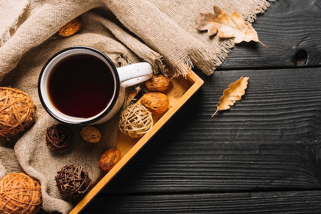 Dried leaves and fabric near tray with beverage