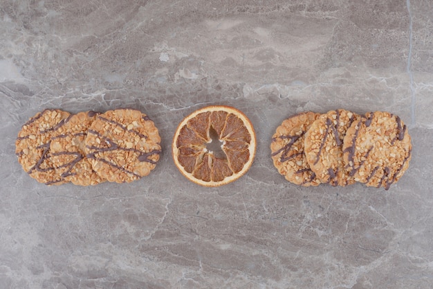 Foto gratuita fetta di limone secca e biscotti su marmo